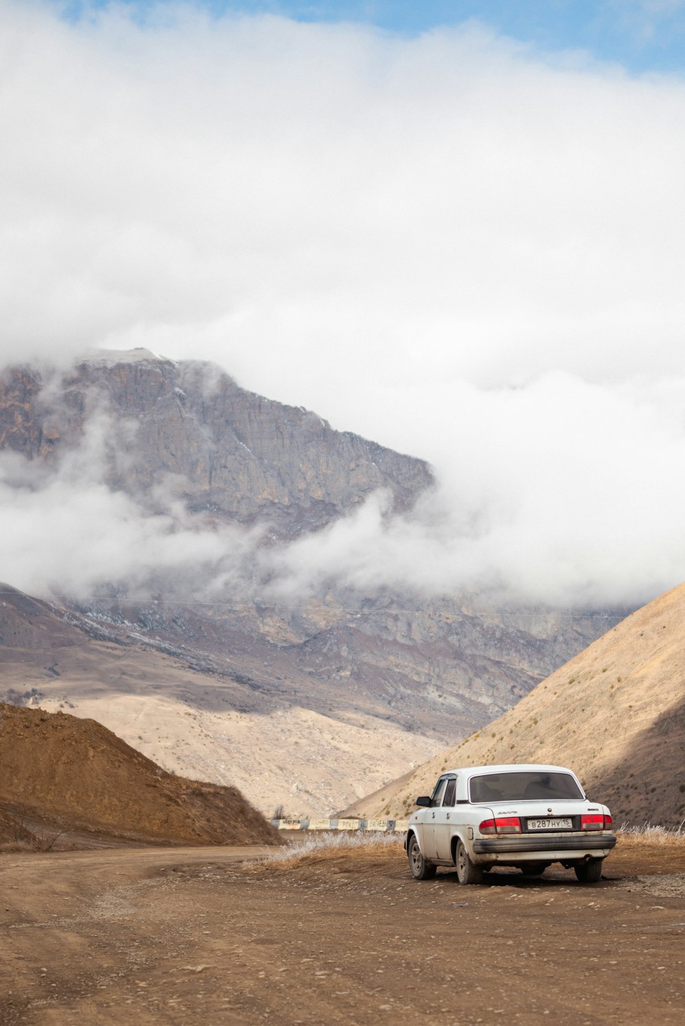 a truck parked on a dirt road in the mountains