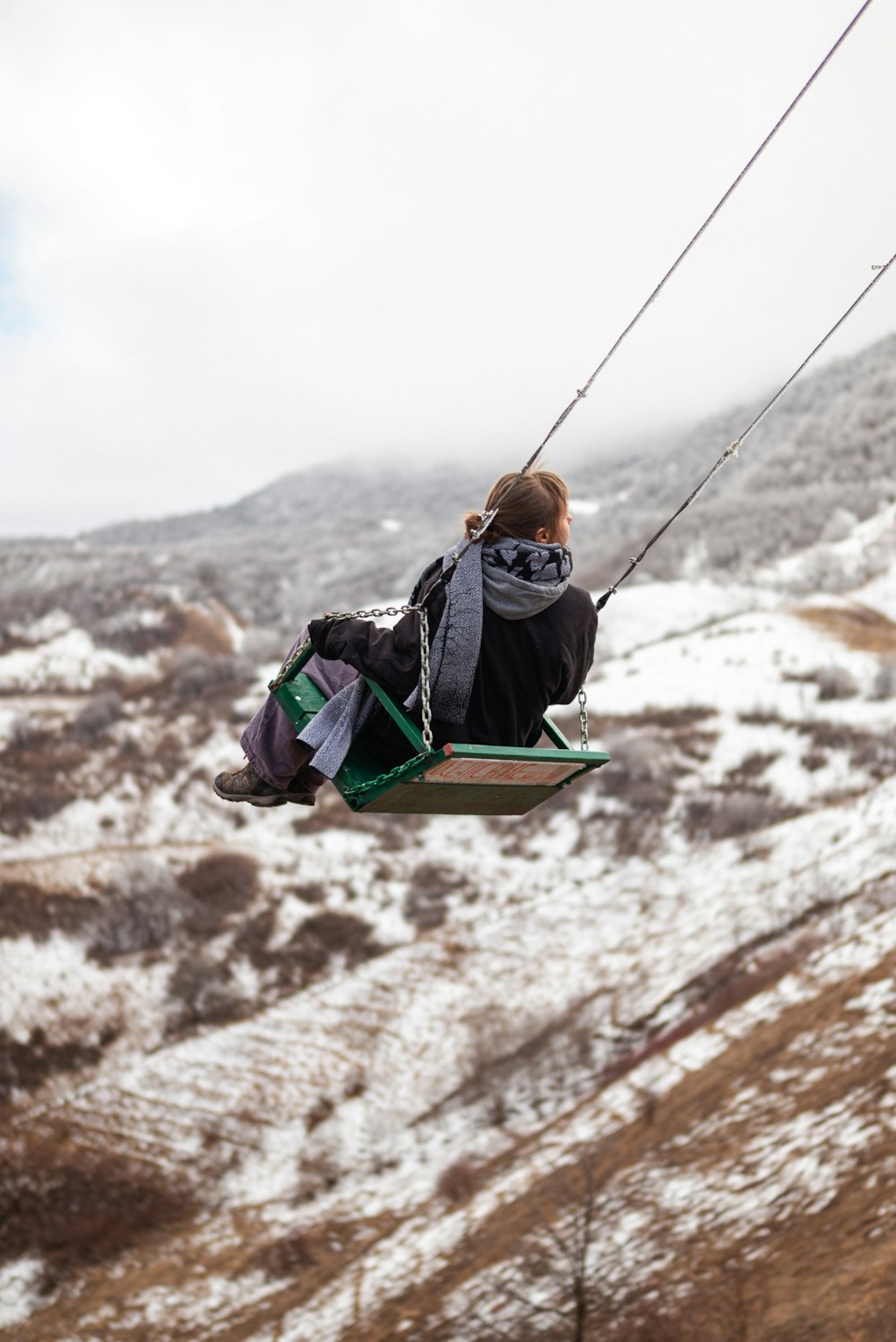 a person riding a zip line in the snow