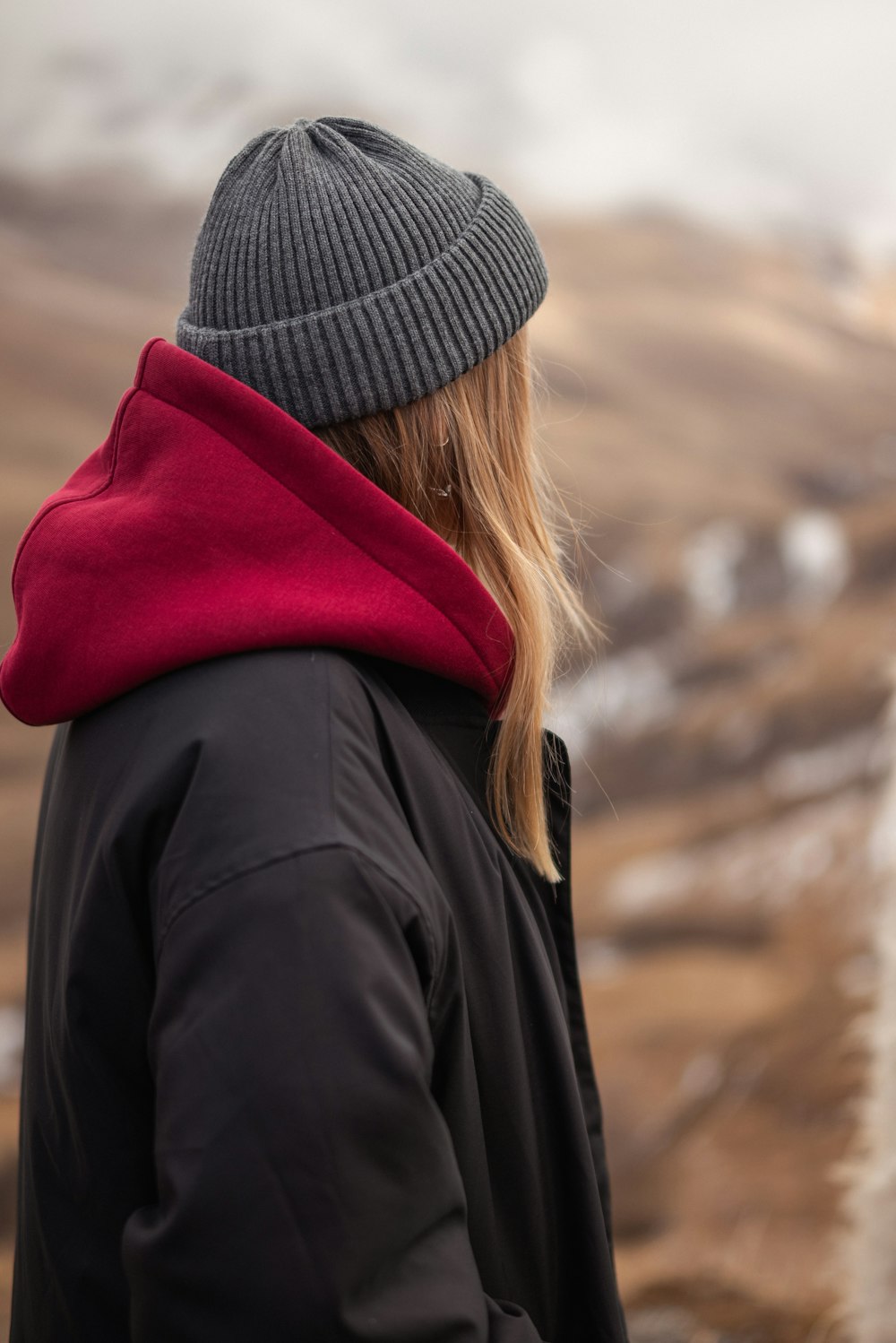 a woman in a black jacket and a red scarf