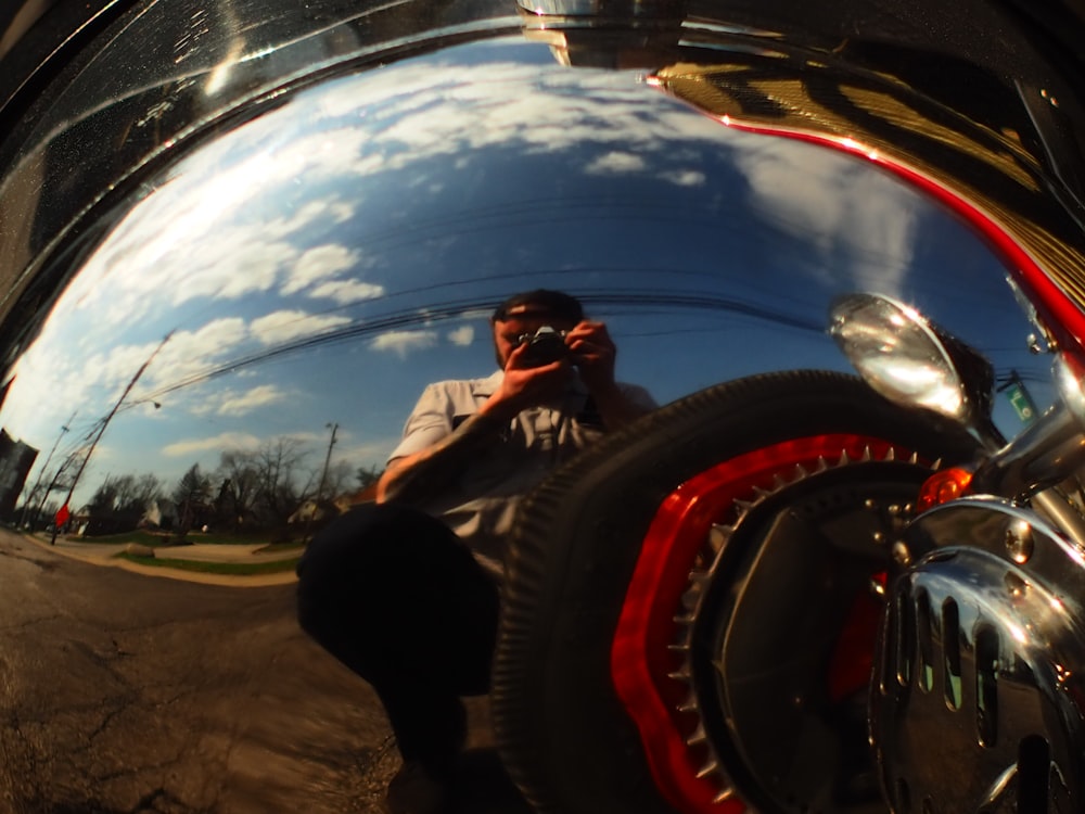 a reflection of a man sitting on a motorcycle