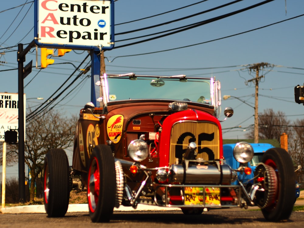 a red and blue car parked in front of a center auto repair sign