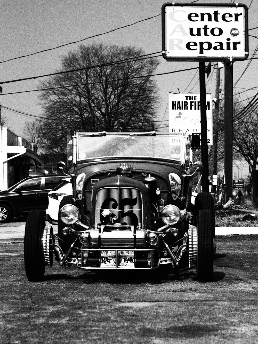 a car parked in front of a sign for a hair salon