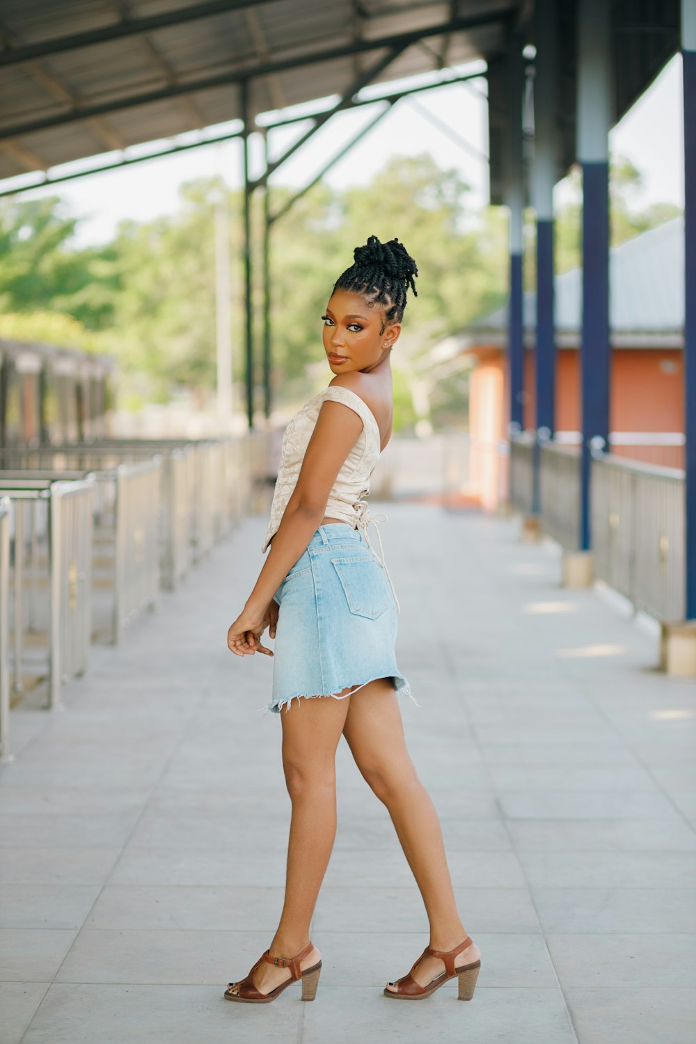 a woman in a white top and blue denim skirt