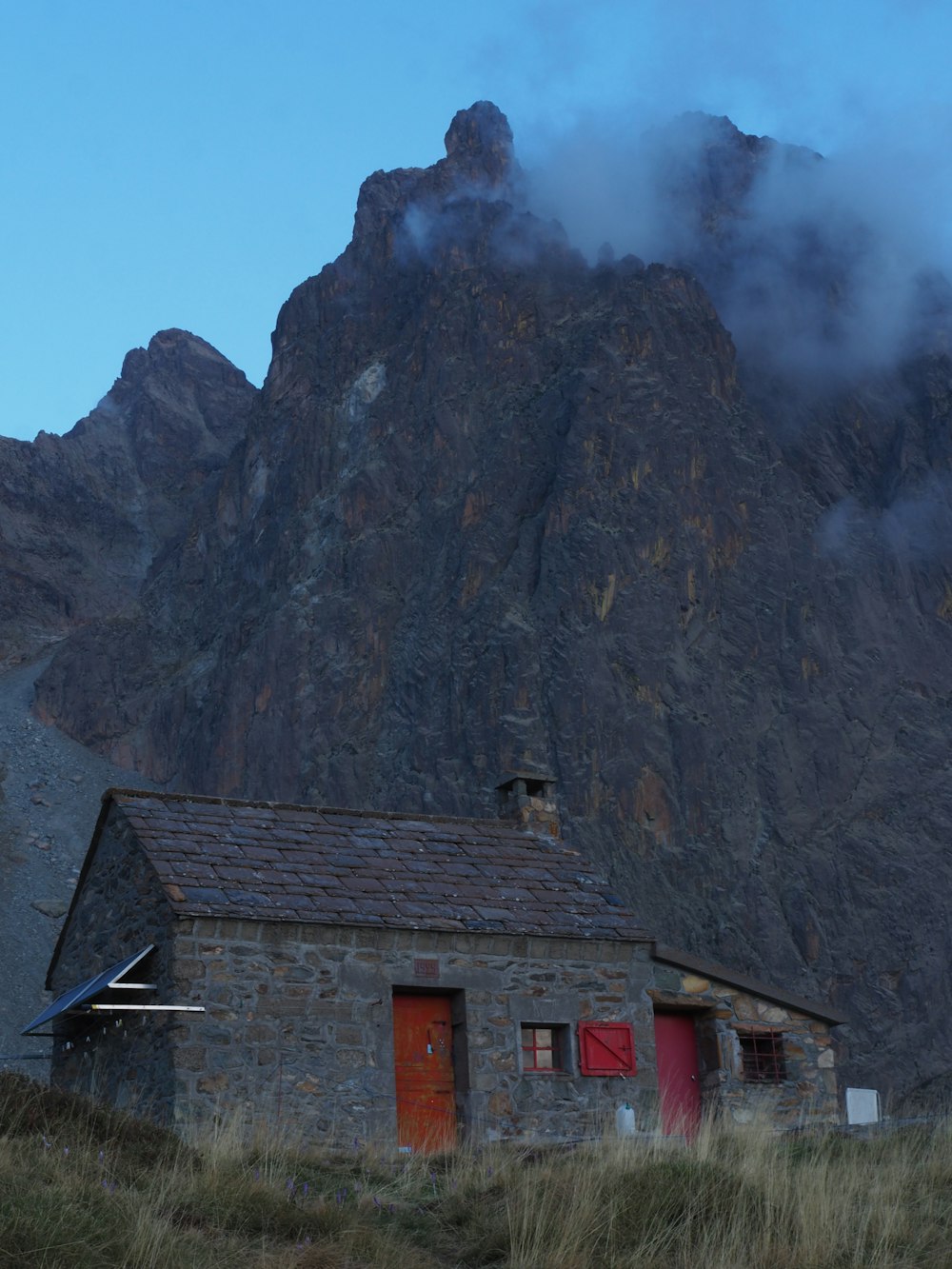 a small building with a mountain in the background