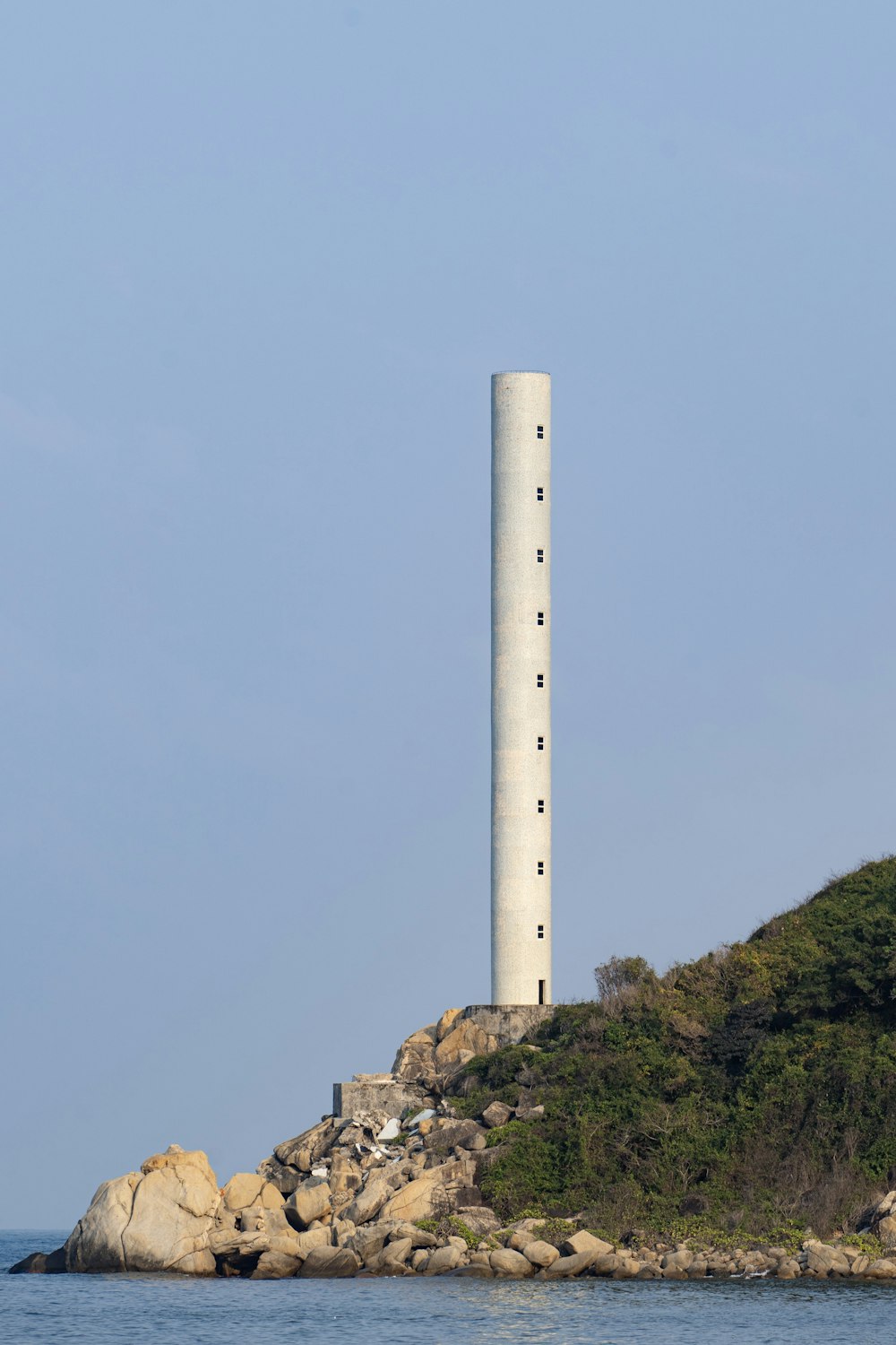 a white tower sitting on top of a small island