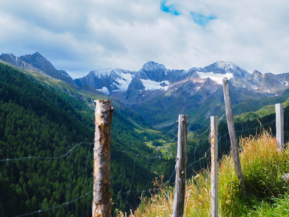 a fence in the mountains with a mountain range in the background