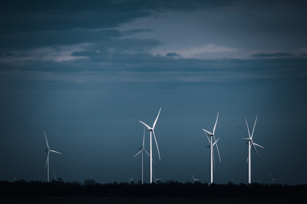 a group of windmills in a field at night