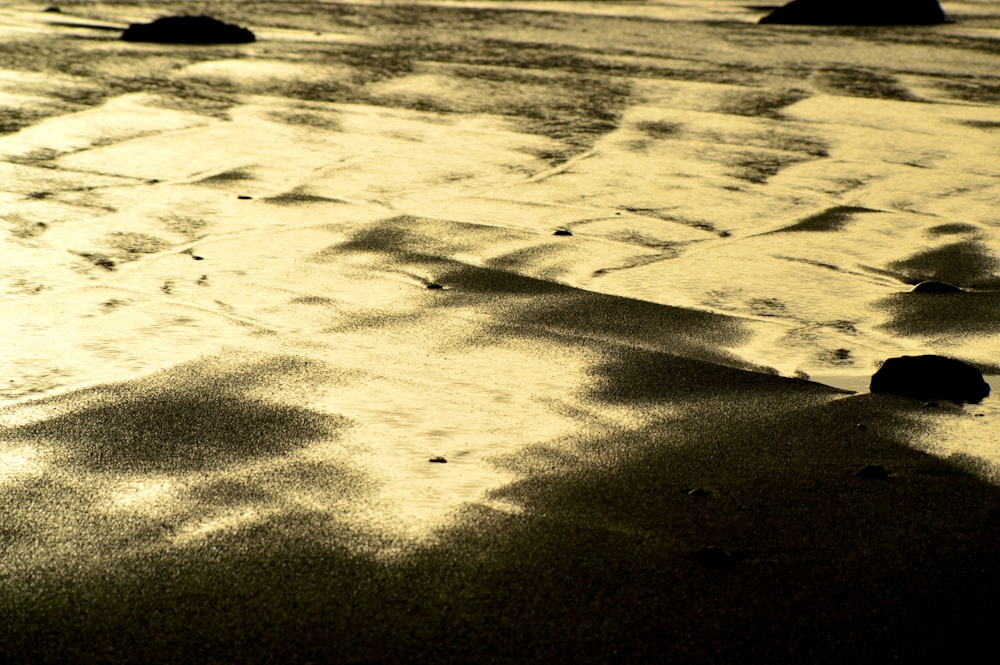 a black and white photo of sand and water