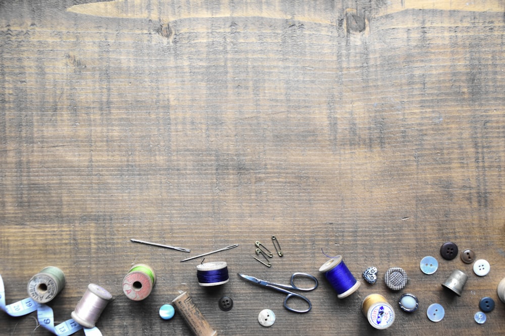 una mesa de madera cubierta con muchos tipos diferentes de hilo