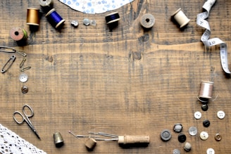 a wooden table topped with lots of sewing supplies