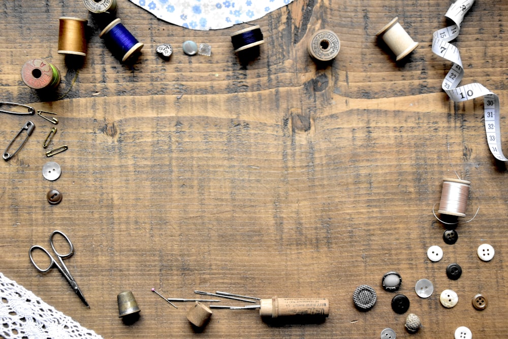 a wooden table topped with lots of sewing supplies