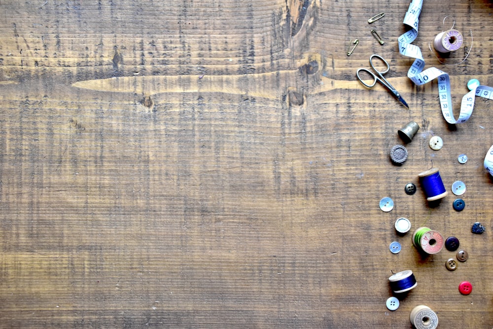 a wooden table topped with lots of sewing supplies