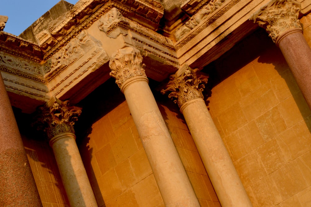 a building with columns and a clock on the side of it