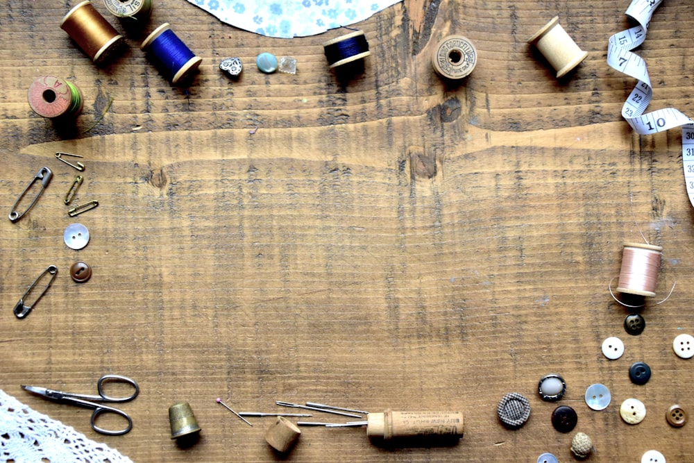 a wooden table topped with lots of sewing supplies