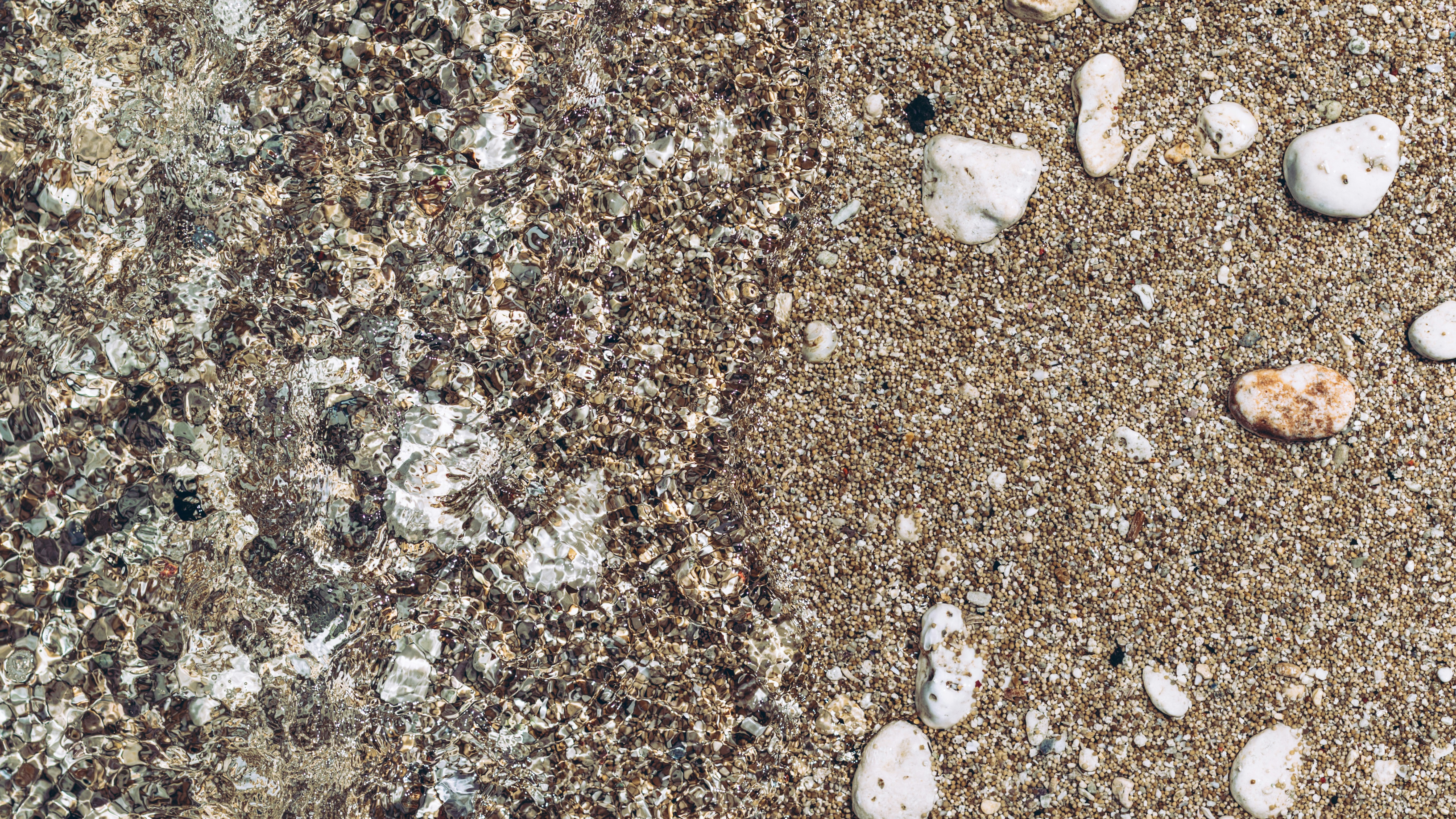 a sandy beach covered in lots of small rocks