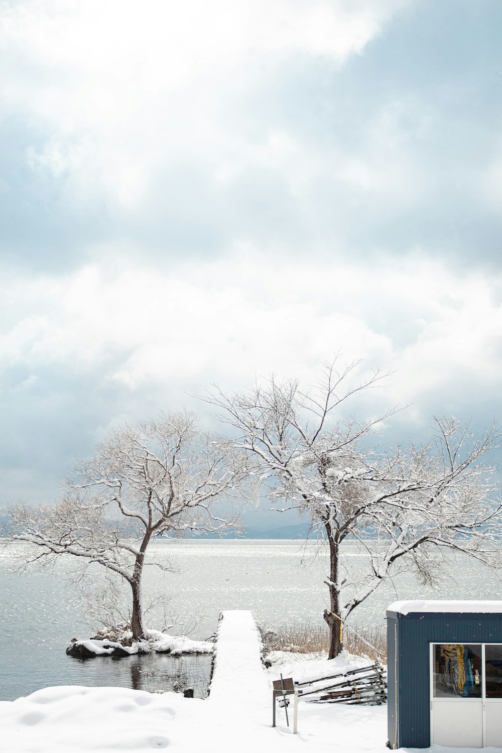 a snow covered walkway leading to a body of water