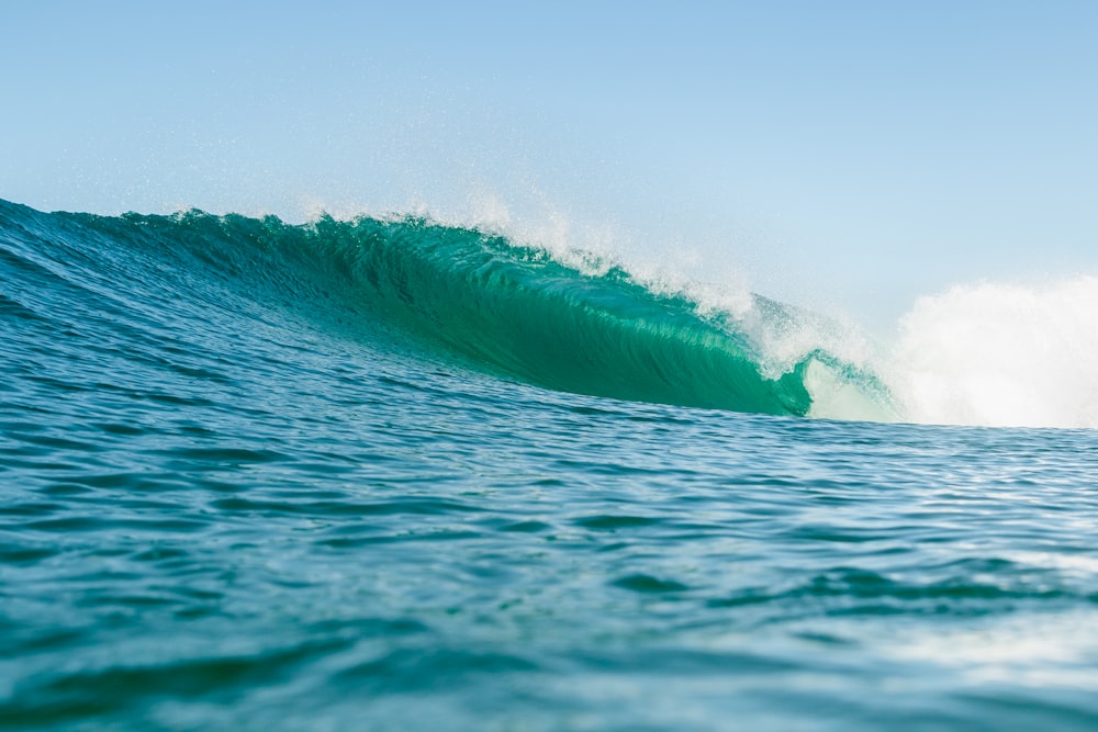 a large green wave in the middle of the ocean