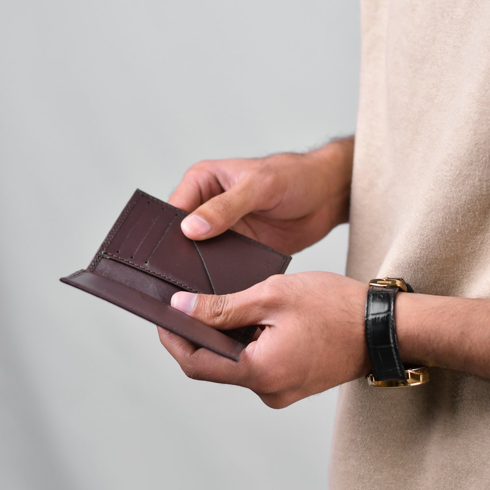 una persona che tiene un portafoglio in mano