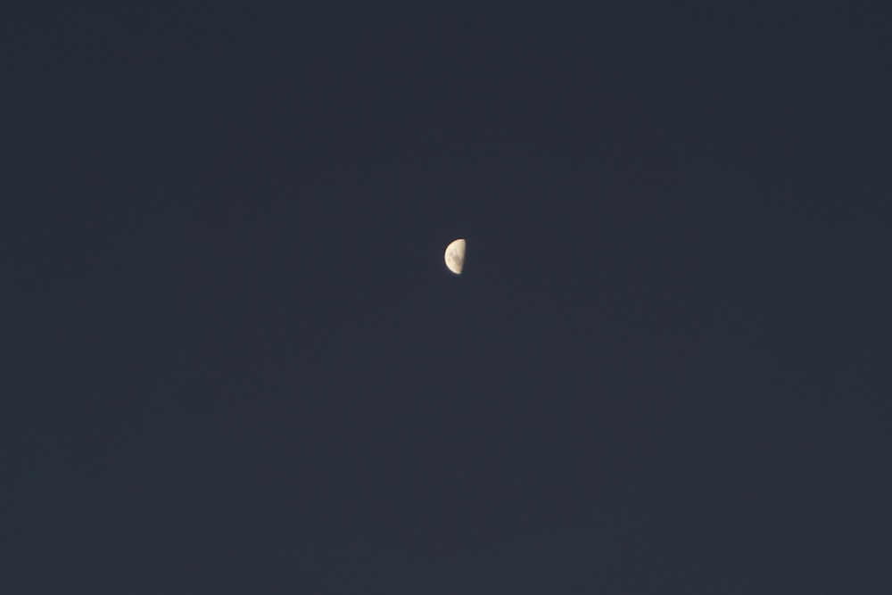 a half moon is seen in a dark sky