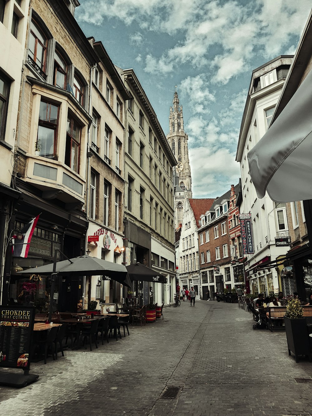 a street with tables and umbrellas on the side of it