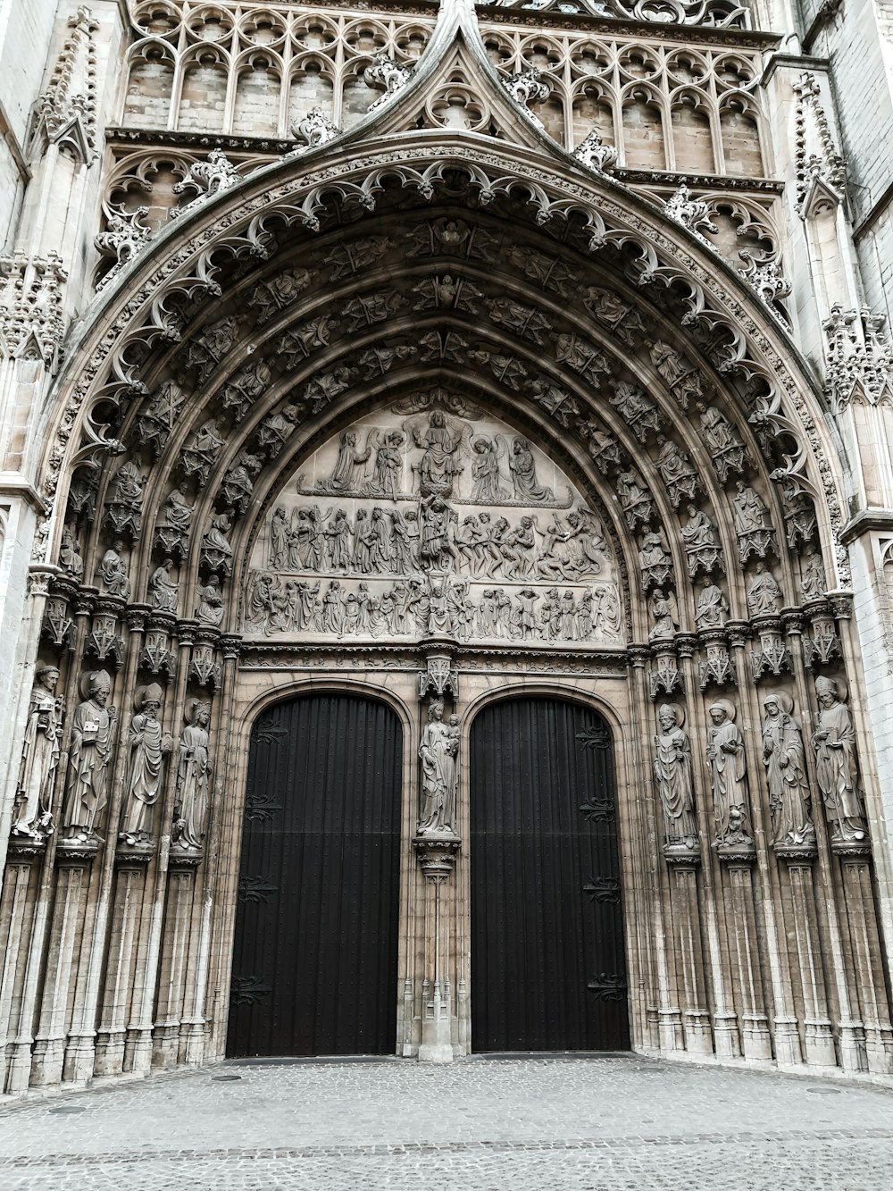 a large stone building with two black doors