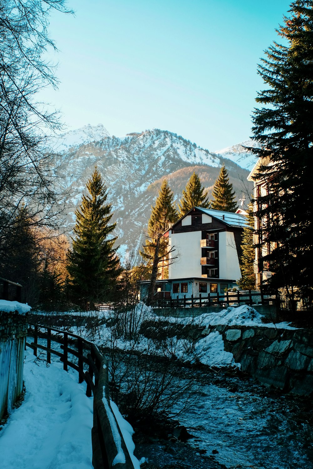 a house in the mountains with snow on the ground