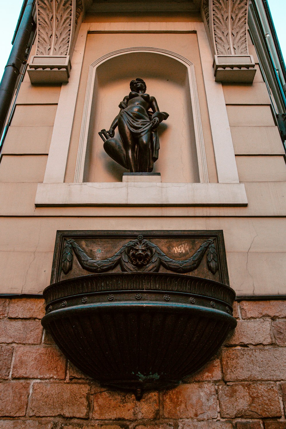 a statue of a woman sitting on top of a window sill