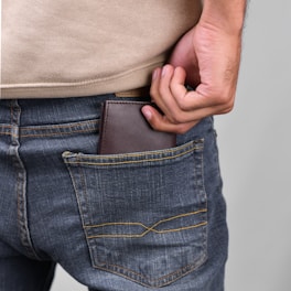 a man is holding his wallet in his pocket