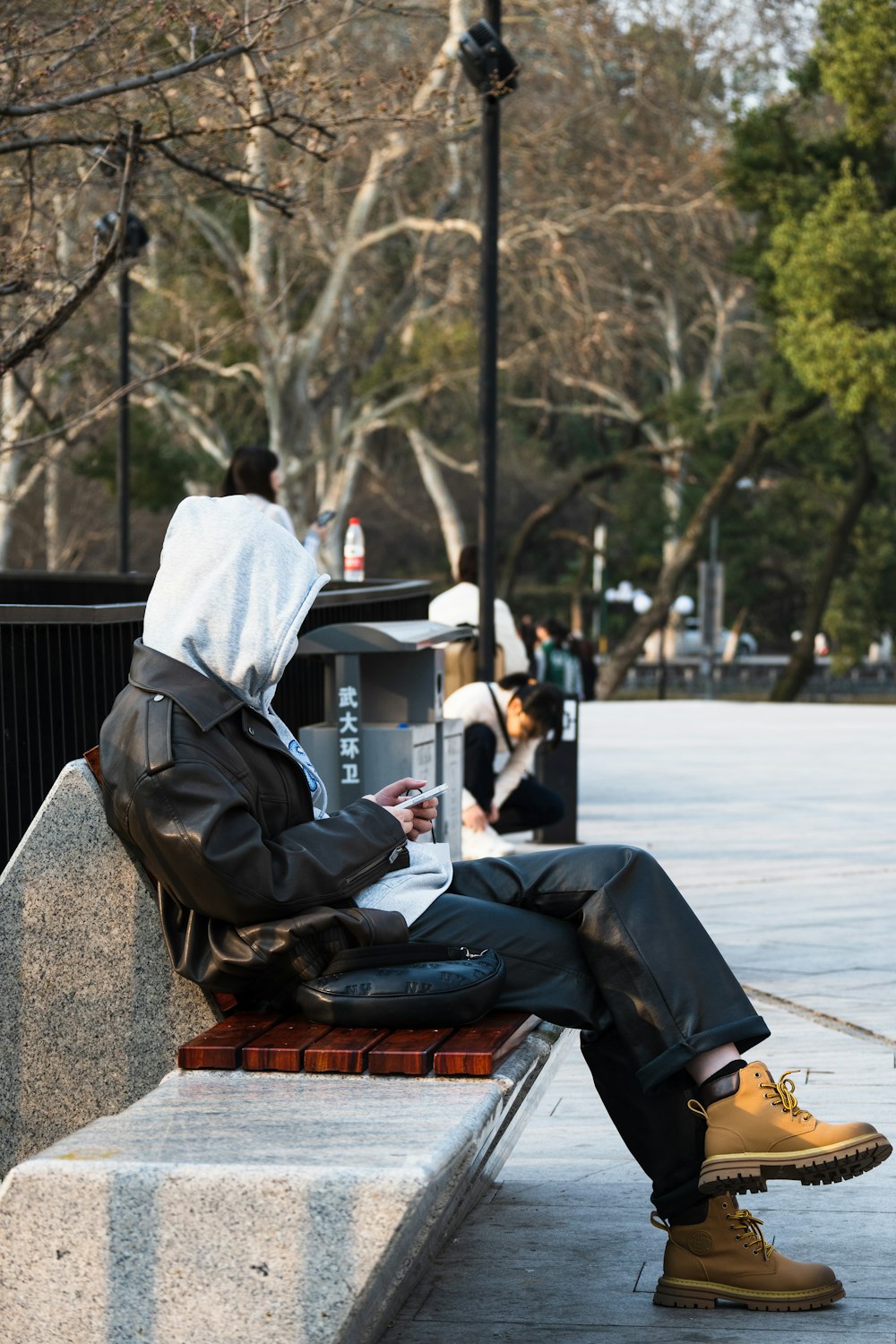 a person sitting on a bench using a laptop