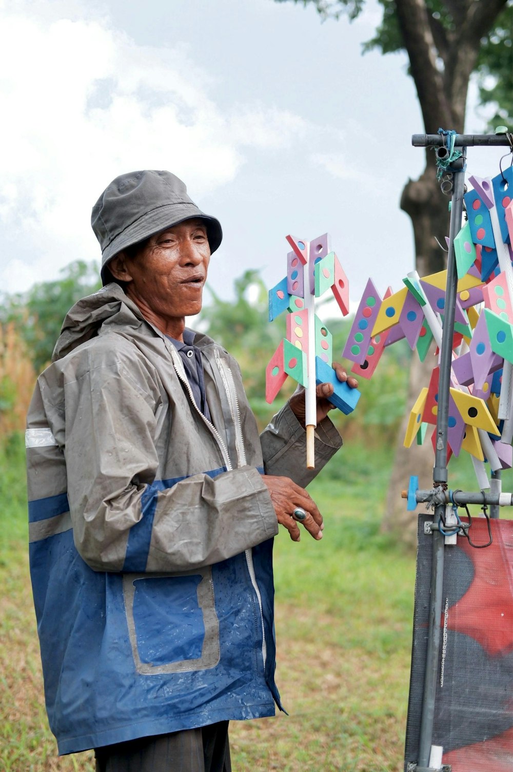 a man standing next to a easel with a bunch of pinwheels on