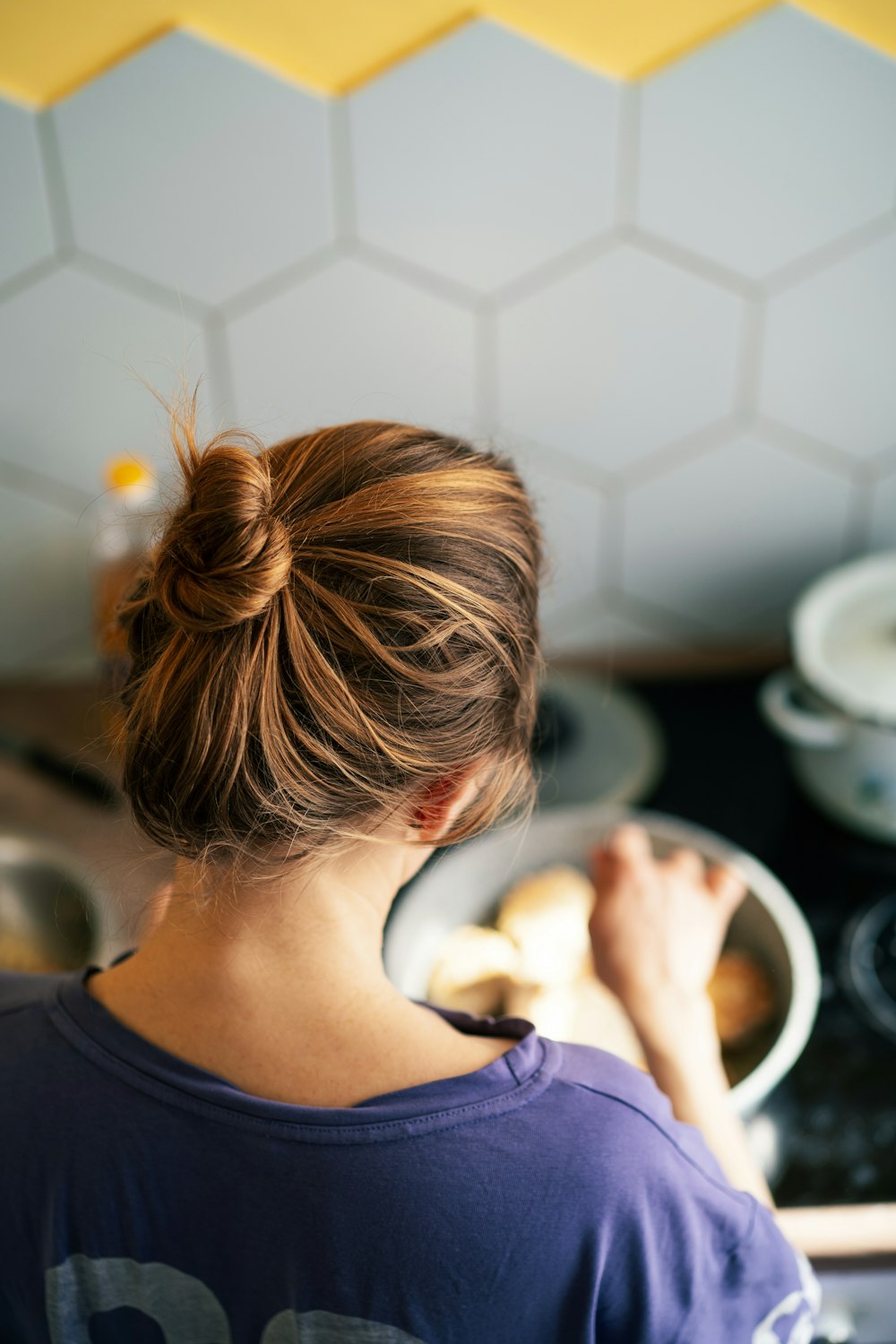 a woman standing in a kitchen preparing food