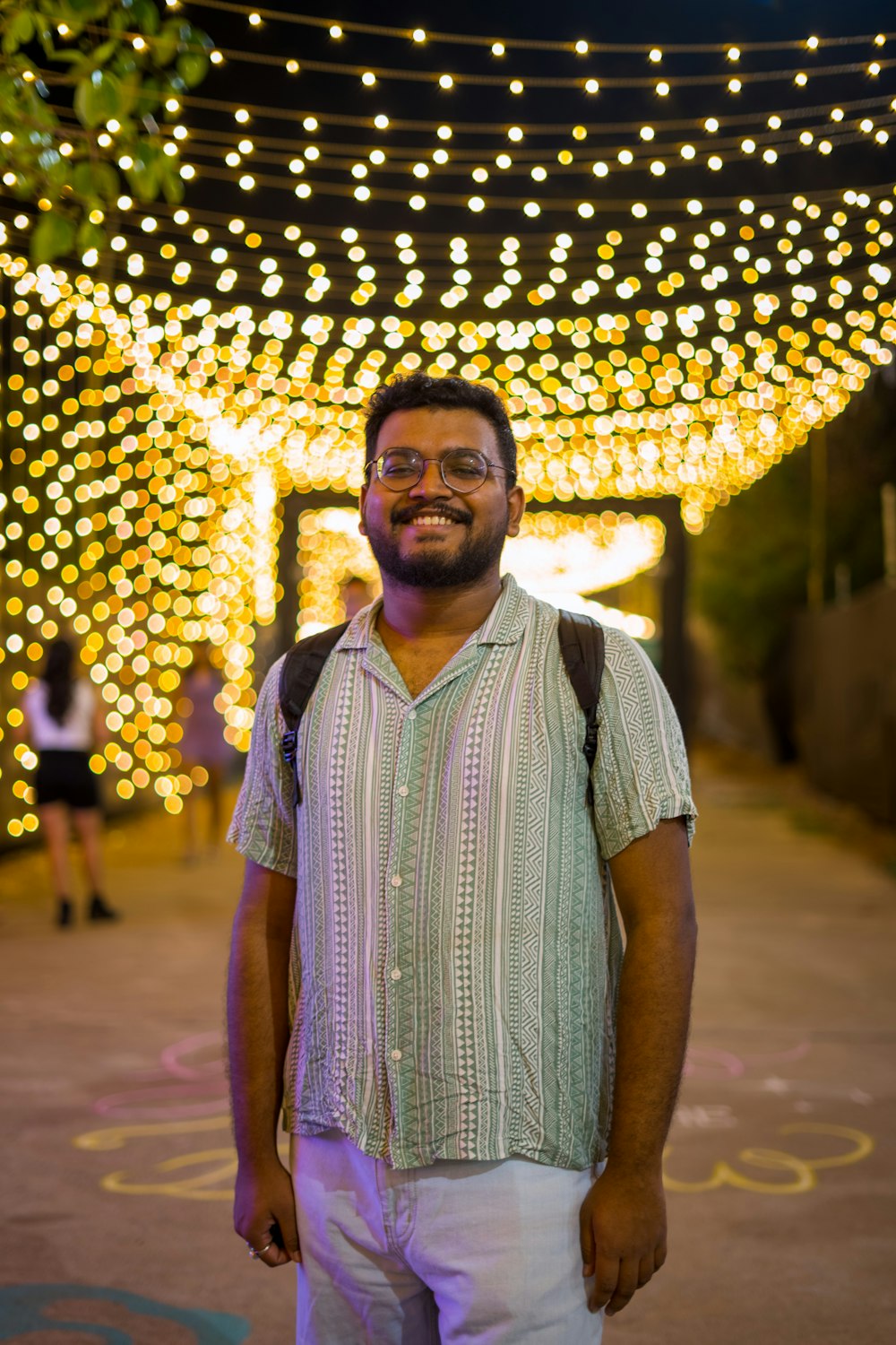 um homem parado em frente a um túnel de luzes