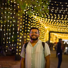 a man standing in front of a tunnel of lights