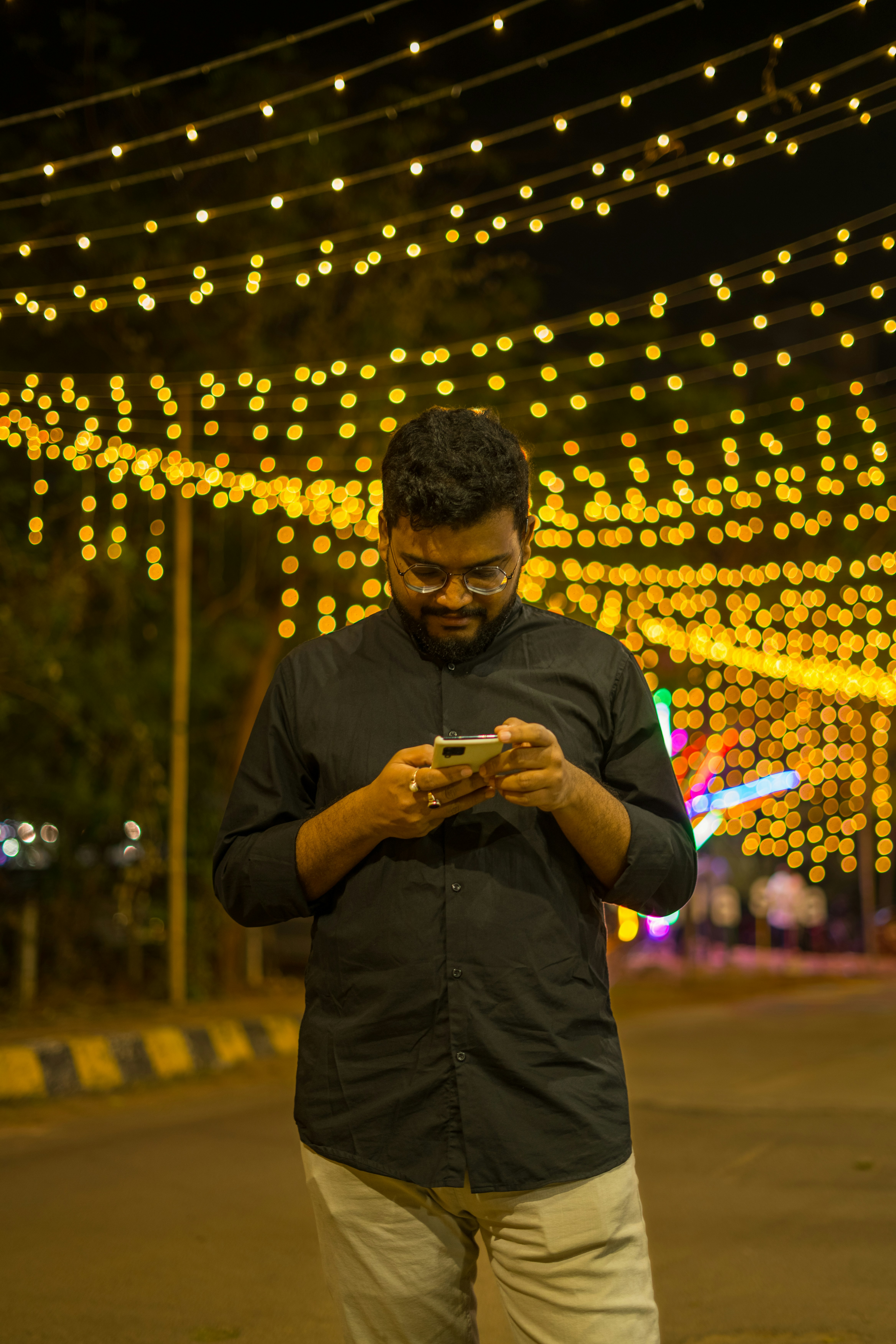 a man standing on a street looking at his cell phone
