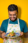 a man in an apron holding a plate of food