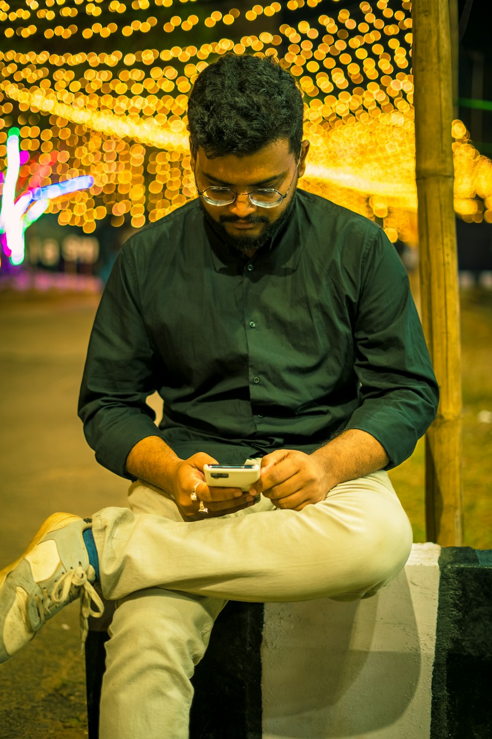 a man sitting on a bench looking at his cell phone