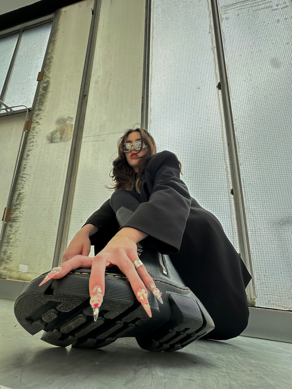 a woman sitting on the ground with her hand on a suitcase