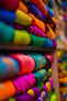 a bunch of colorful t - shirts are stacked on a shelf