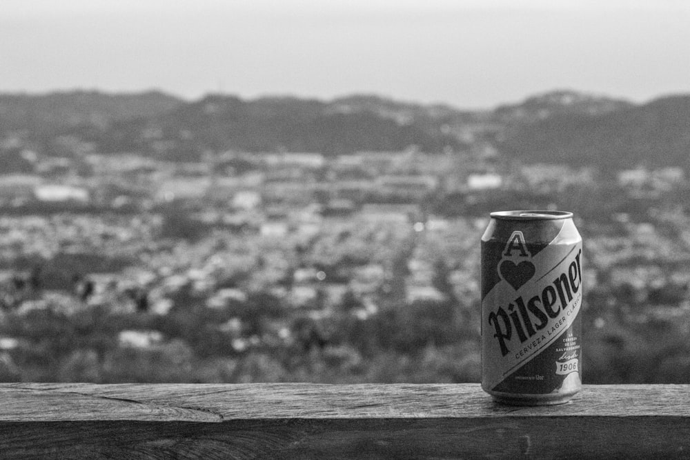 a can of beer sitting on top of a wooden table