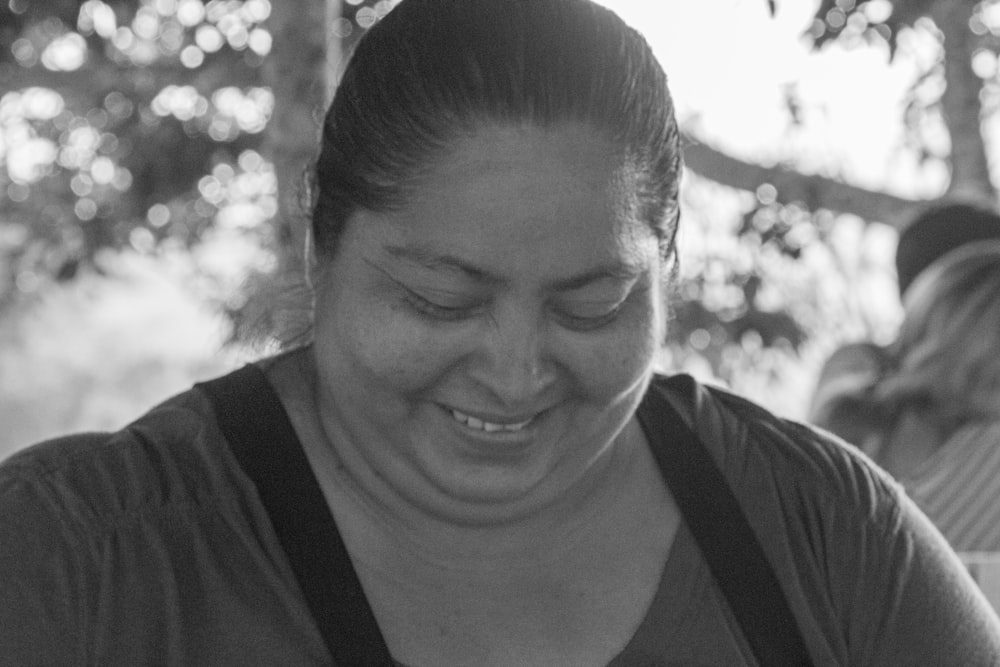 a black and white photo of a woman smiling