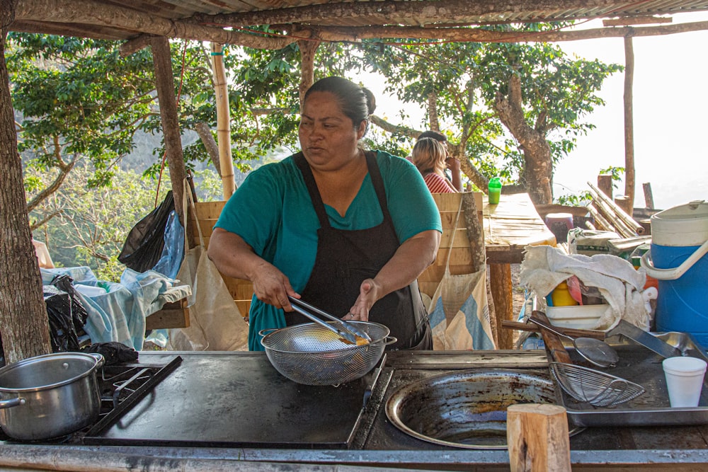 a woman cooking food on top of a stove