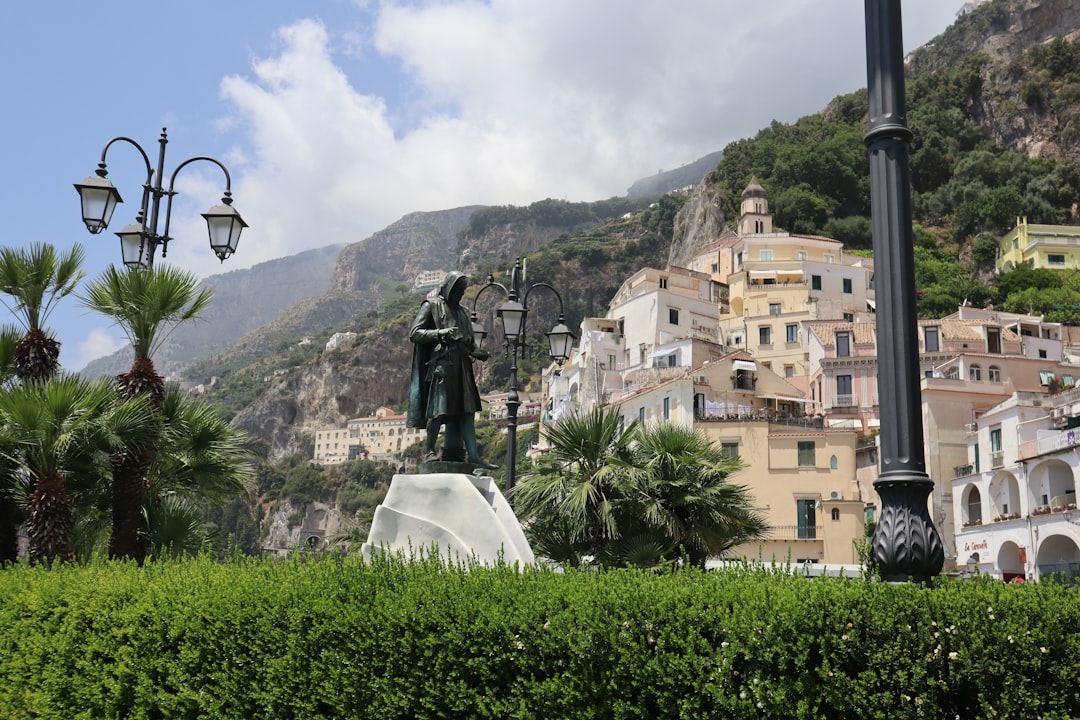 a statue of a man standing on top of a white pedestal, 