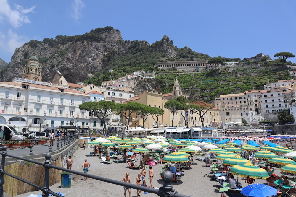 a crowded beach with umbrellas and people on it