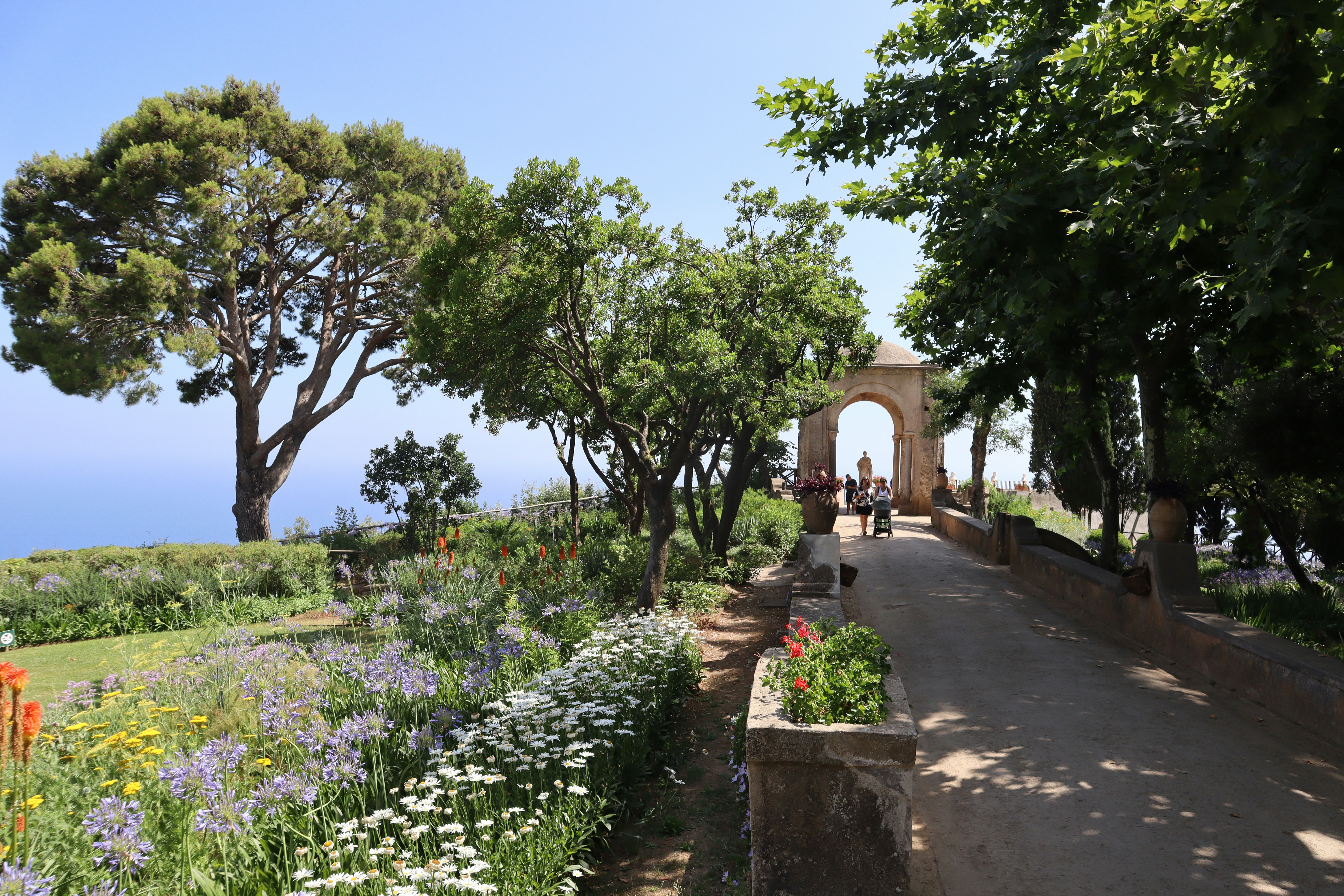 a pathway with flowers and trees on both sides of it - Amalfi