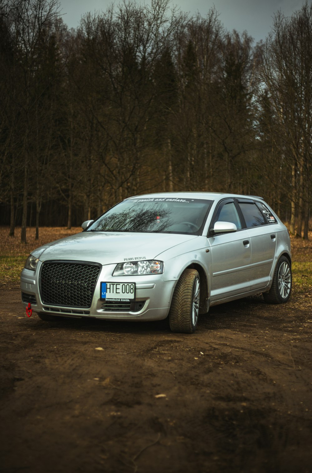 a silver car parked on a dirt road