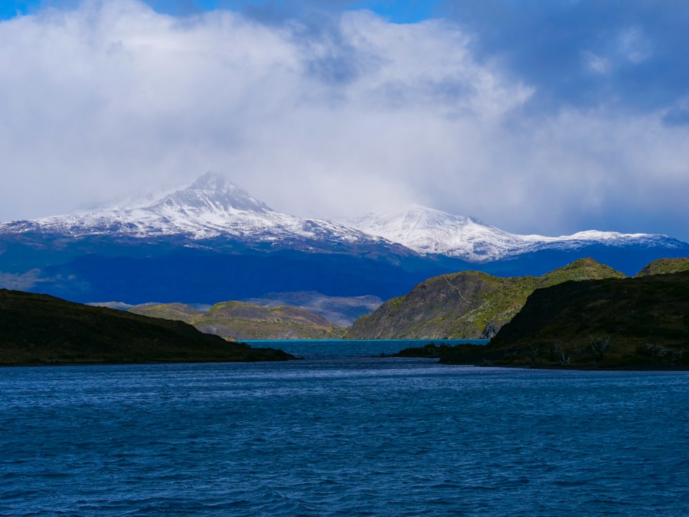 a large body of water with a mountain in the background