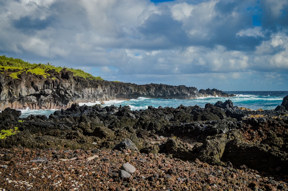 a rocky beach with waves crashing on the rocks