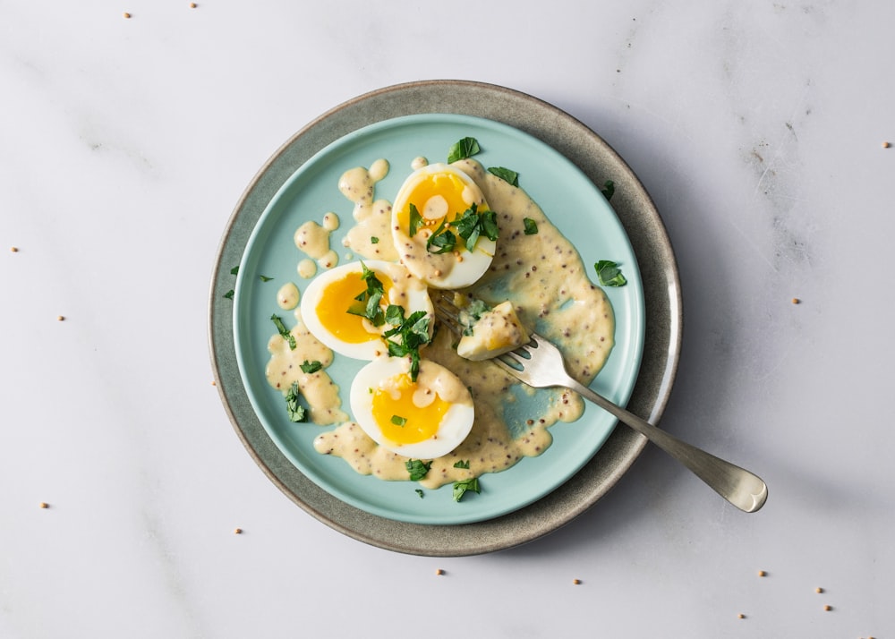 a blue plate topped with eggs and pasta