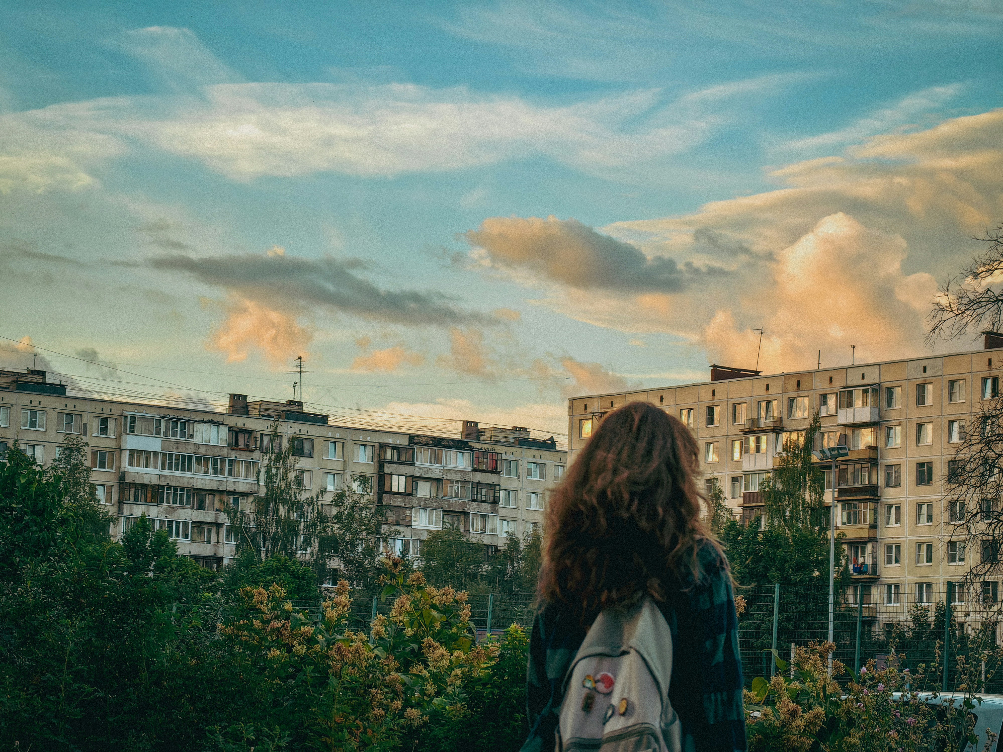 a woman with a backpack looks out over a city
