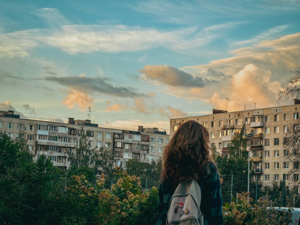 a woman with a backpack looks out over a city